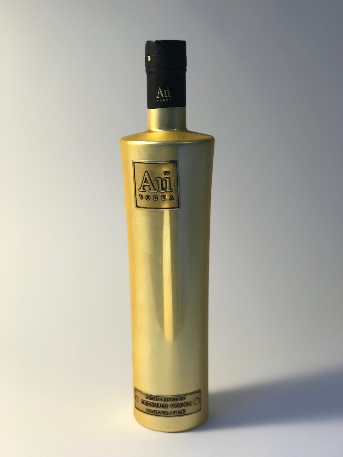 A golden bottle of Au Vodka with a black sleeve over the lid and a label reading "5 times distilled premium vodka, 40% alc vol 70cl"